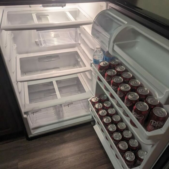 Fridge filled with Dr Pepper cans, showcasing a typical 'Dude Fridge' setup with minimal other items.