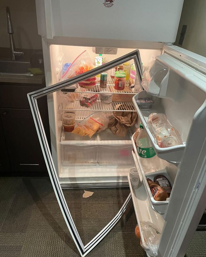 Disorganized fridge with removed door frame, various food items scattered inside, representing chaotic dude fridges.