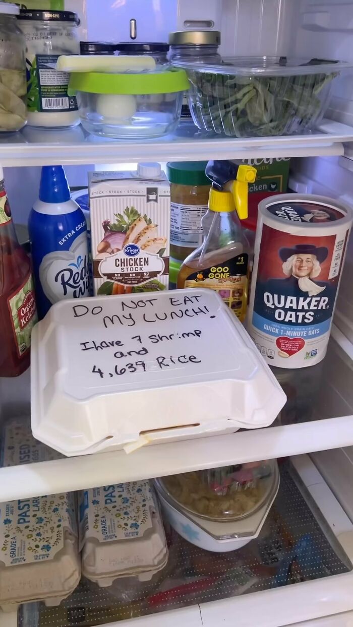 Dude fridge with comical note on takeout container amidst various groceries.