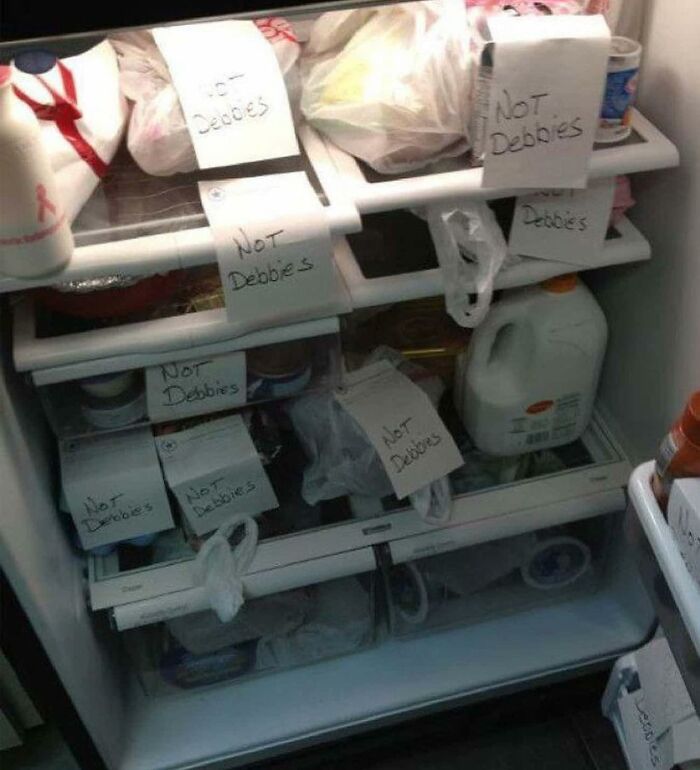 Fridge filled with items labeled "Not Debbie's," showcasing chaos from the Instagram account dedicated to dude fridges.