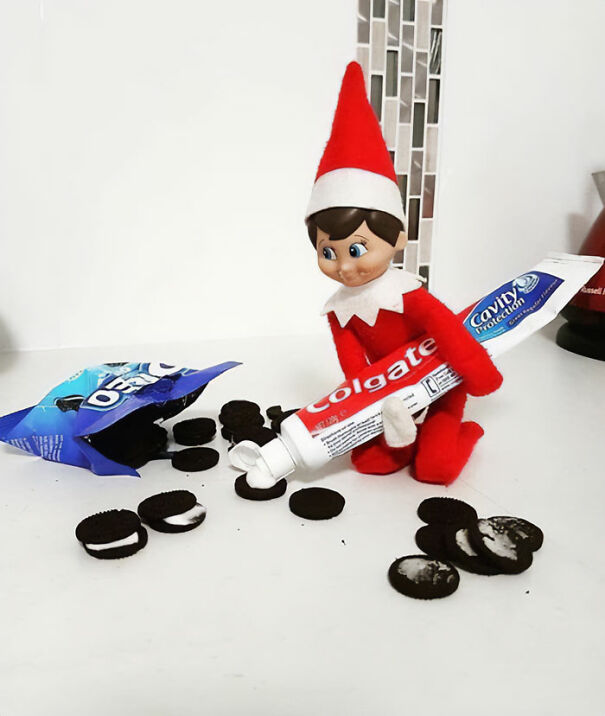 "Elf On The Shelf idea with an elf mischievously replacing Oreo cream filling with toothpaste, creating a prank setup with scattered cookies."