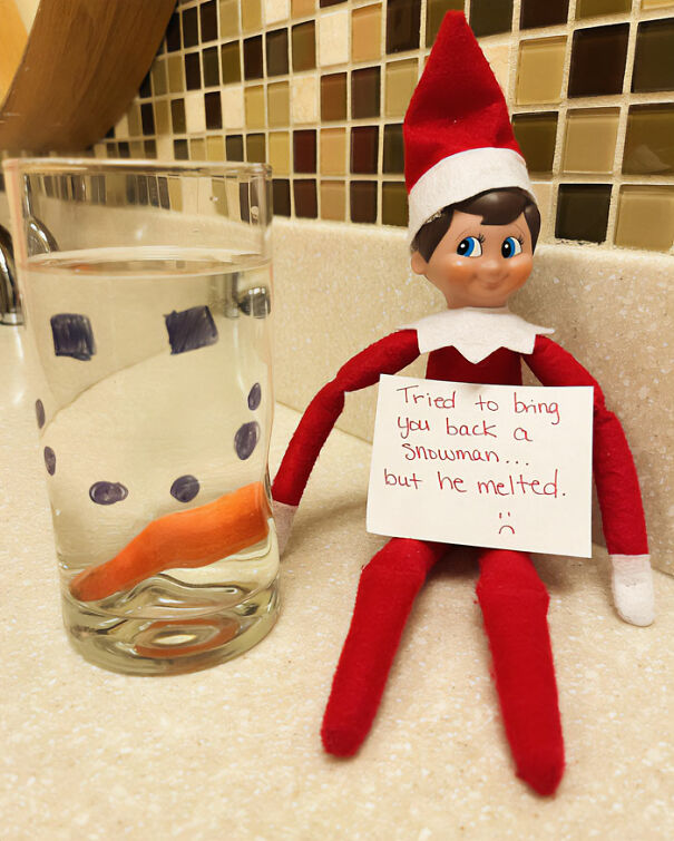 "Elf On The Shelf idea with an elf holding a sign saying 'Tried to bring you back a snowman... but he melted,' next to a glass with drawn snowman features."