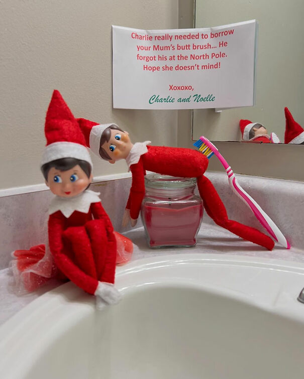 "Elf On The Shelf idea with two elves on a bathroom counter; one holding a toothbrush, a note humorously apologizes for borrowing it."