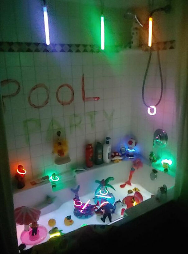 "Elf On The Shelf idea with a bathtub decorated as a 'pool party' featuring glow sticks, toy animals, and rubber ducks for a festive scene."