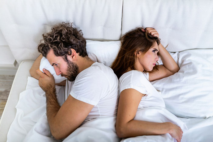 Man and woman in bed, facing away from each other, illustrating attempted manipulation and called bluff.