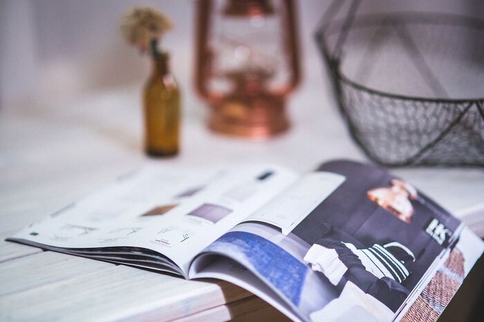 Open luxury magazine on a table, symbolizing wealth.