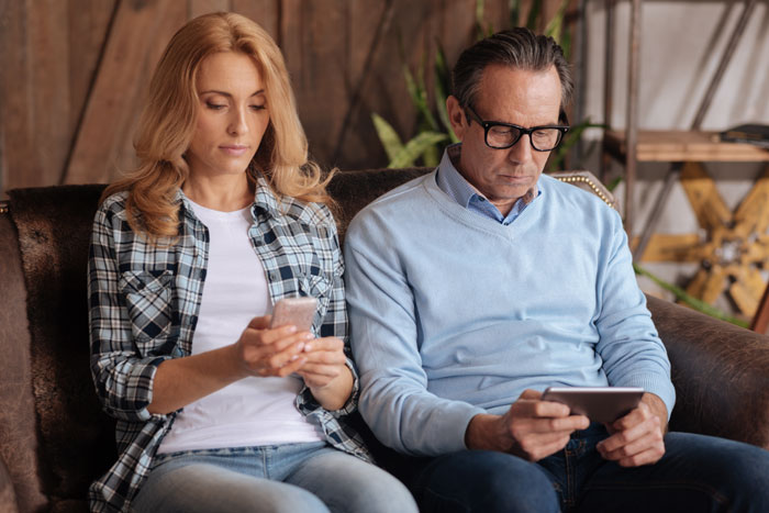 Parents focused on their devices, possibly concerned about their child's date activities.