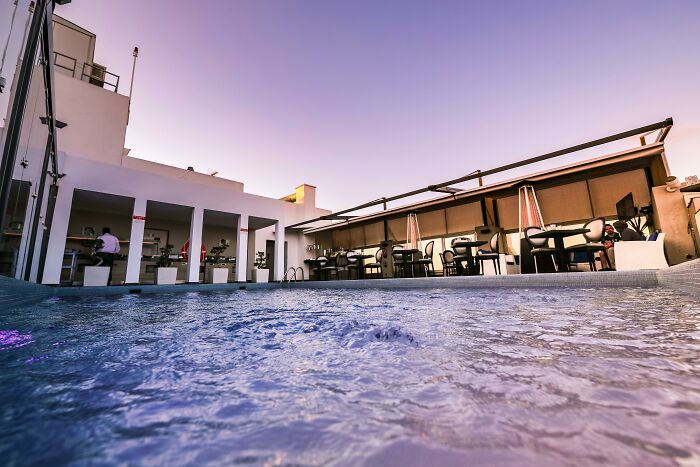 Rooftop luxury pool area at sunset indicating wealth.