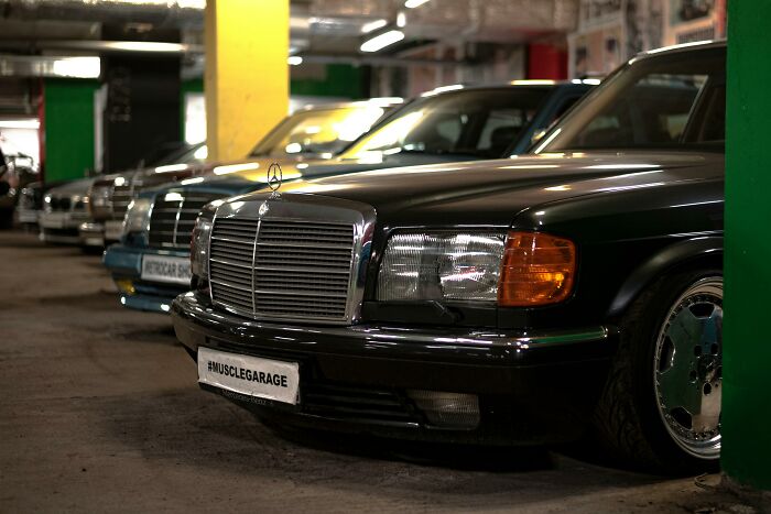 Luxury cars in a garage, indicating wealth.