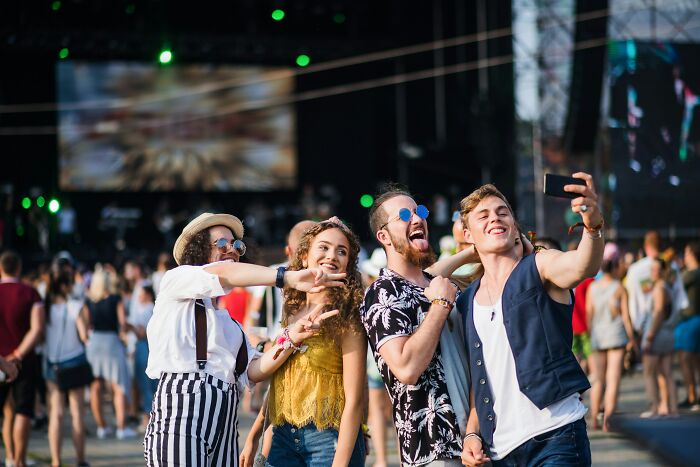 Group of friends at a festival taking a selfie, highlighting moments of doubt before marrying someone.