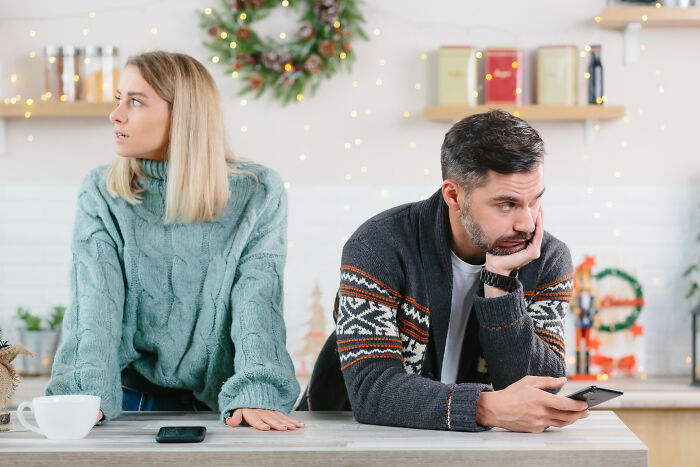 Couple with tense expressions at a kitchen counter, illustrating a moment of doubt about marriage.