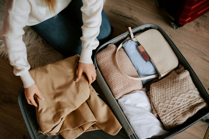 Person packing a suitcase on the floor, symbolizing a decision not to marry.