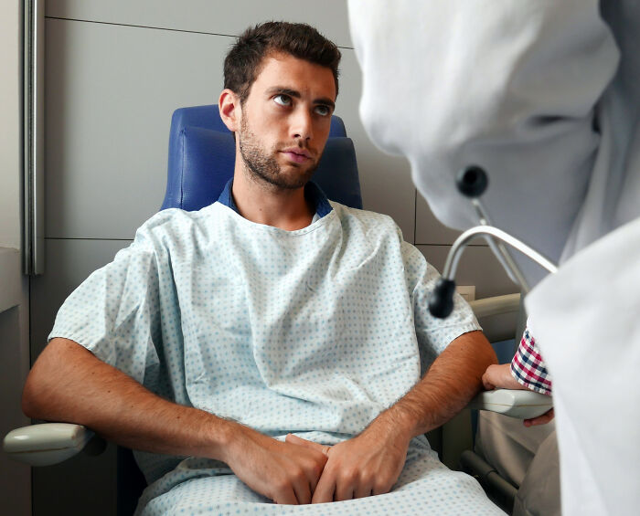 Man in hospital gown looking skeptical, highlighting moments when marriage doubts arise.