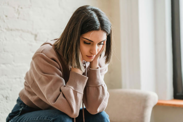 A woman appearing thoughtful indoors, symbolizing refusing to pay rent.