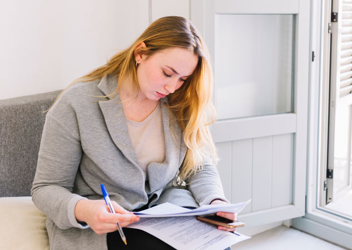 Woman reviewing documents at home, related to refusing to pay rent.