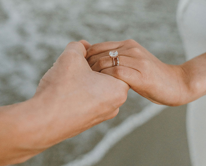 Hands holding each other with a wedding ring, symbolizing signs of a failing marriage.