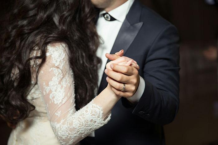 Couple dancing in formal attire, holding hands, possibly indicating signs a marriage could fail.