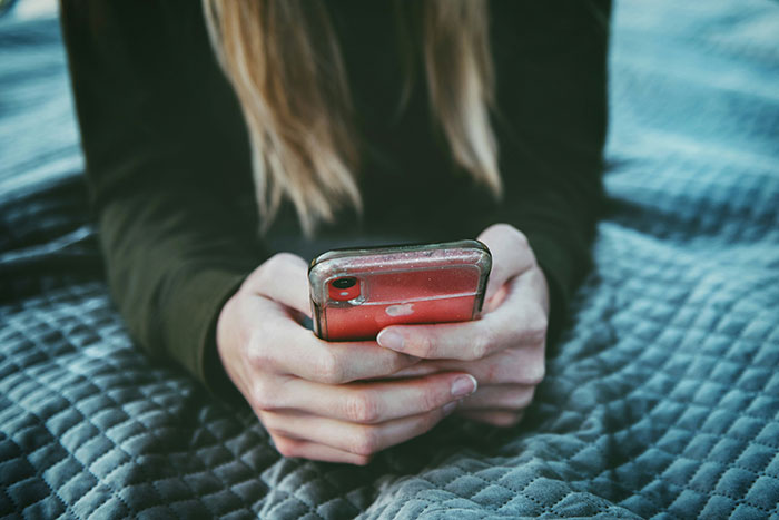 Person holding a smartphone, symbolizing communication issues in failing marriages.