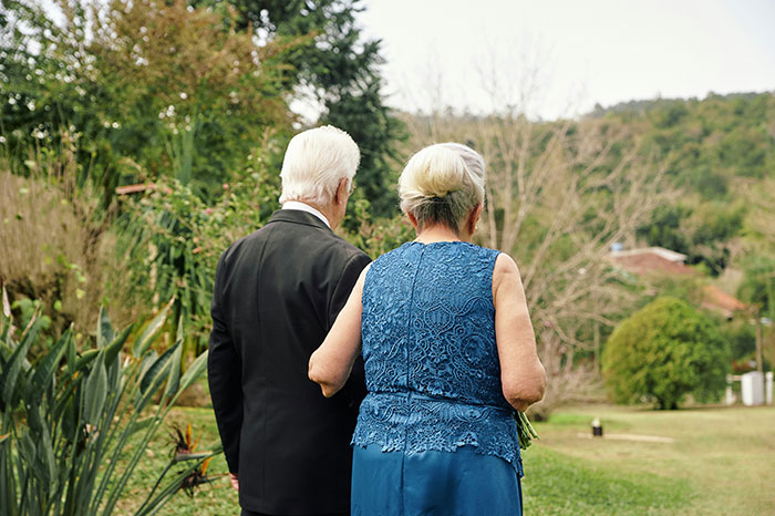 Older couple walking in a garden, symbolizing wisdom and insights on signs a marriage is destined to fail.