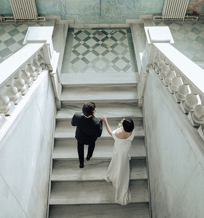 Bride and groom walking up marble stairs, symbolizing signs of marriage challenges.