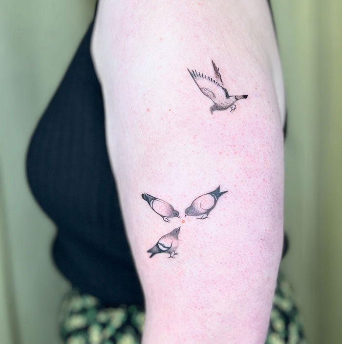 Minimalist bird tattoos on a woman's arm, showcasing subtle tattoo ideas for women.