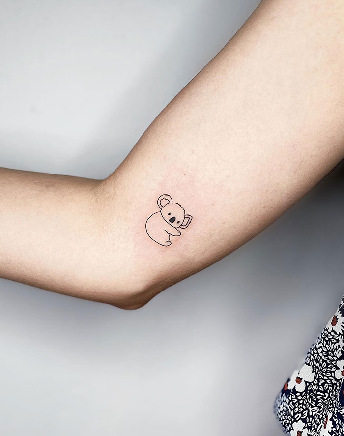 A tattoo idea for women with a minimalist koala tattoo design on a woman's arm, showcasing subtle tattoo ideas.