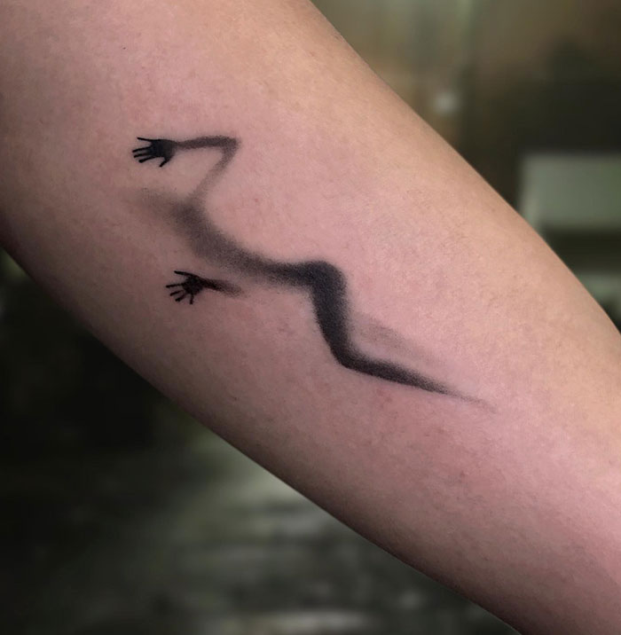 A tattoo idea for women with a unique tattoo design with abstract lines and small hands on a woman's arm.