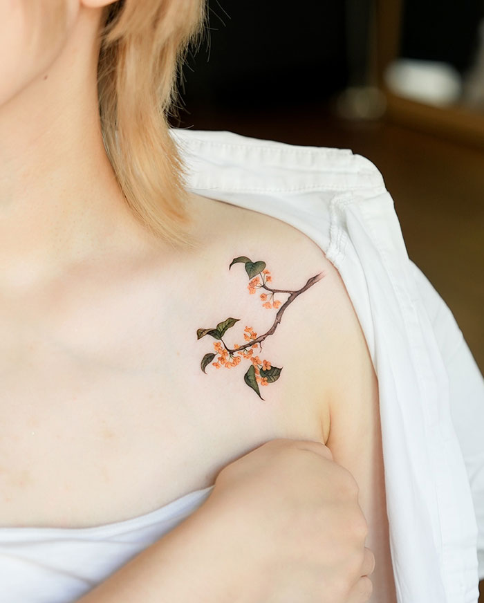 A tattoo idea for women with a flower tattoo on woman's shoulder, showcasing subtle and elegant design ideas.