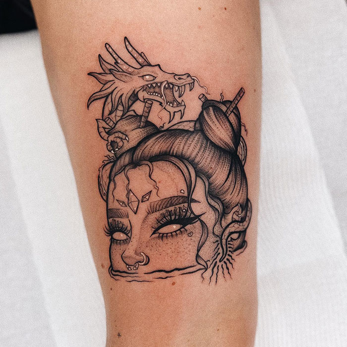 A tattoo idea for women featuring a female face and a dragon on the arm.