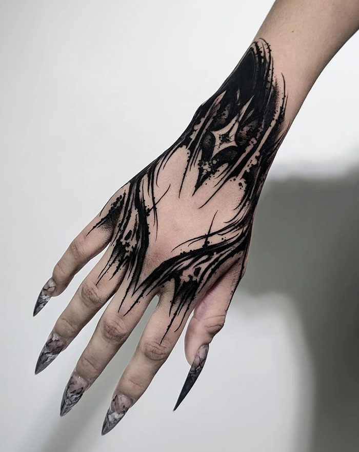 Intricate black hand tattoo idea for women, showcasing daring artistic flair.