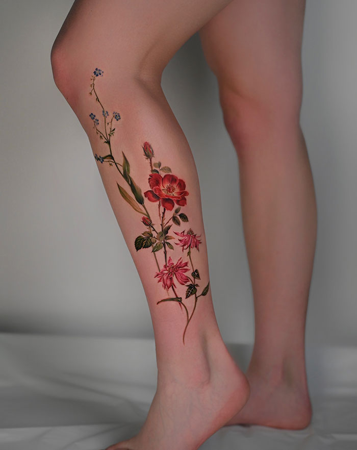 A tattoo idea for women with a floral tattoo on a woman's leg, showcasing daring and subtle design elements.