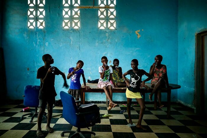 Group of children posing in a vibrant room, showcasing Ivan Margot's photography style.