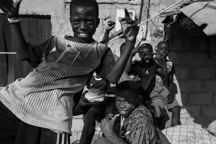 Children pose playfully for a photograph by Ivan Margot, capturing a moment of joy and spontaneity.