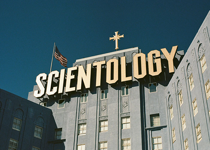 Scientology building facade with a large sign and cross, related to an unexplainable mystery.