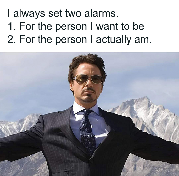 Man in a suit with sunglasses and mountains in the background, paired with a humorous text about setting two alarms.