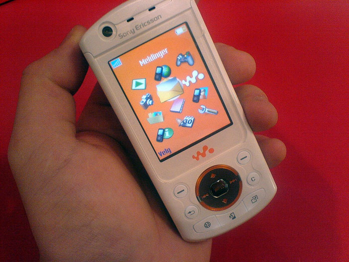 Old Sony Ericsson Walkman phone with orange screen, symbolizing workplace mishaps.