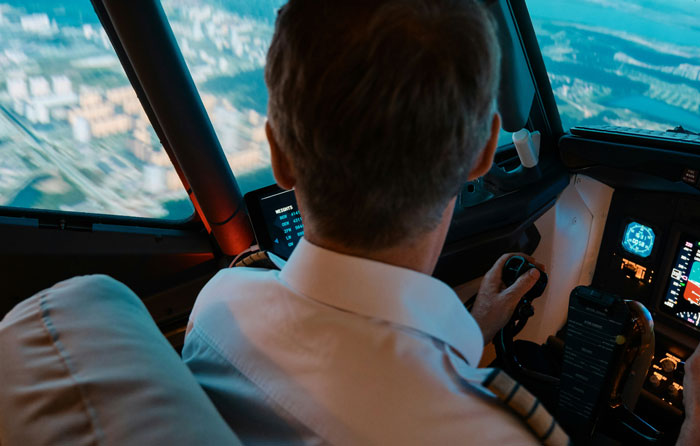 Pilot navigating in a cockpit, highlighting genuine speeding reasons amidst cityscape below.