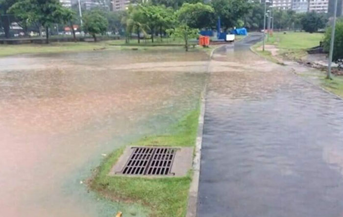 Flooded path with misplaced drain, illustrating a construction mishap.