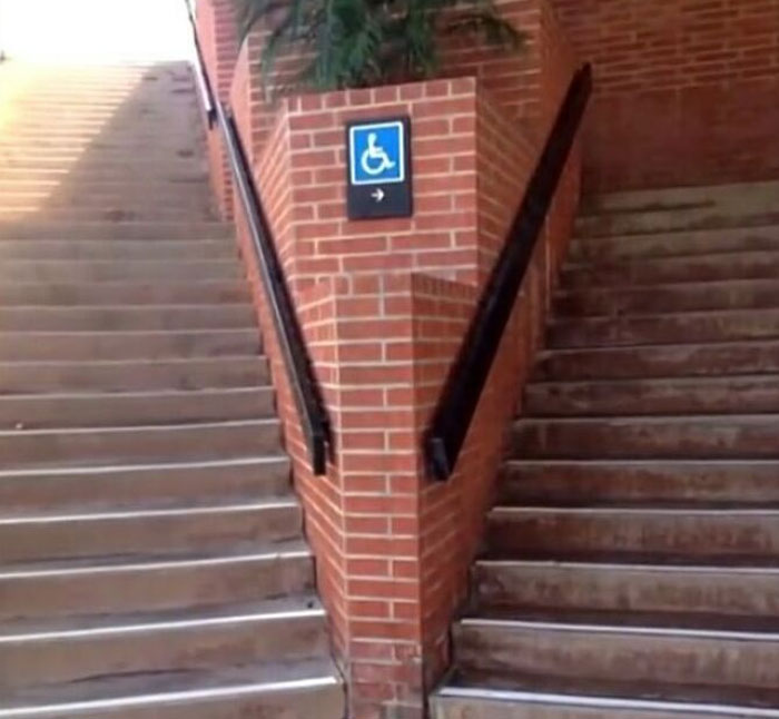 Construction fail showing stairs with a wheelchair sign, highlighting a hilarious oversight in accessibility design.