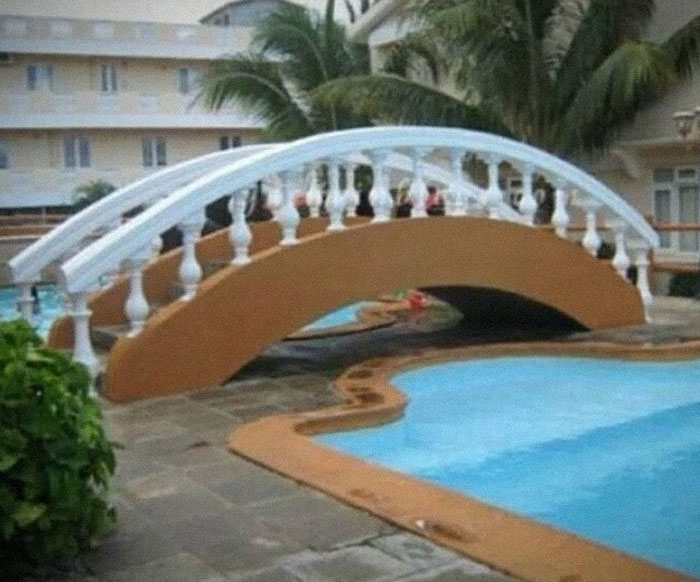 Construction mishap shows a bridge leading nowhere over a pool, illustrating a hilarious fail.