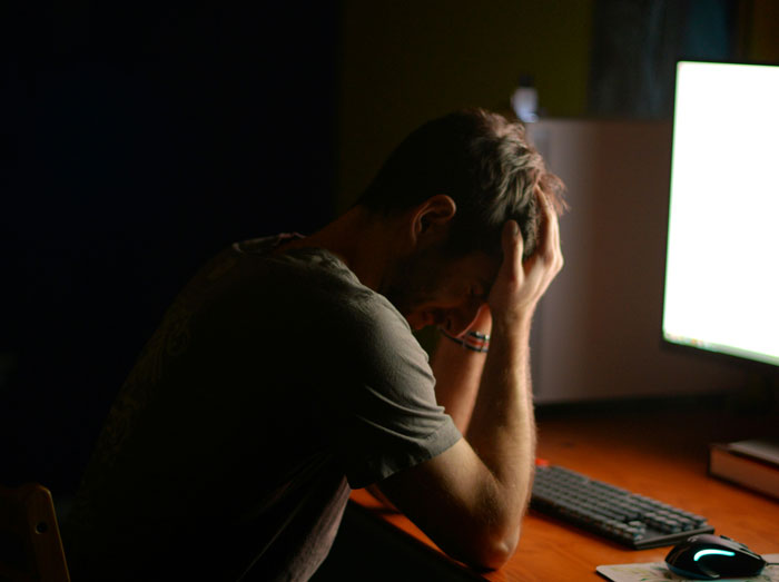 Person stressed in front of a computer, reflecting generational tech struggles with Gen A.