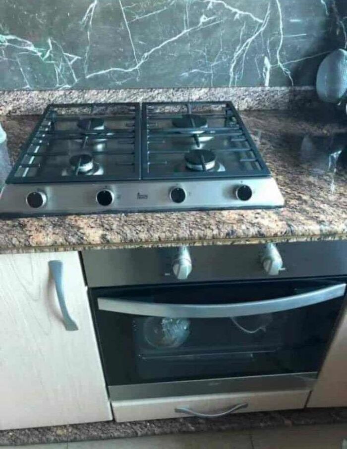 Stove and oven door hilariously misaligned, showcasing a cheap construction fail in a kitchen setting.