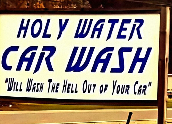 A weird and absurd sign for "Holy Water Car Wash" promises to "wash the hell out of your car."