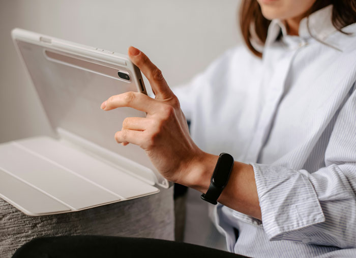 Person in a striped shirt using a tablet, highlighting Gen A's tech interaction.