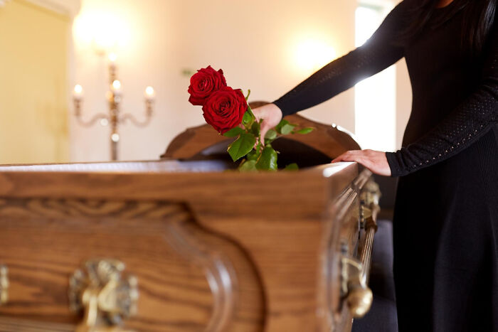 A person places roses on a casket, reflecting on aspects of aging that are harder than expected.