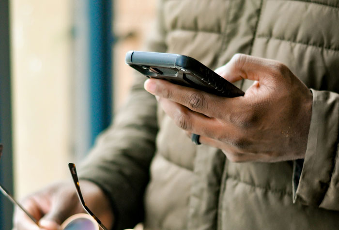 Person holding a smartphone, emphasizing important security measures for device protection.