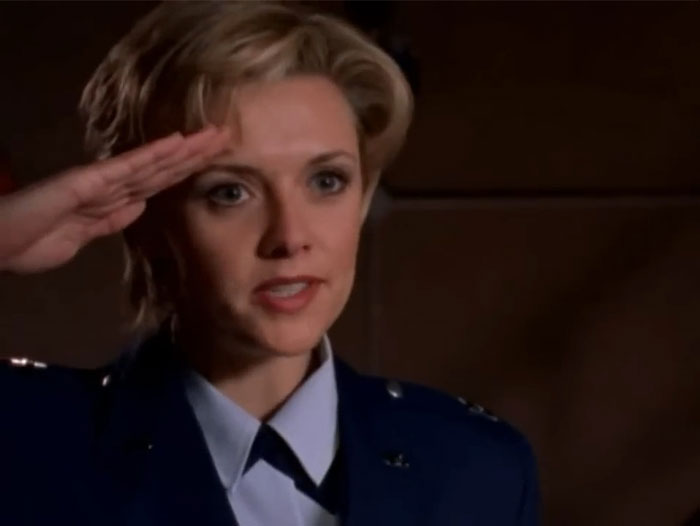 A woman in uniform saluting, embodying a strong female protagonist.