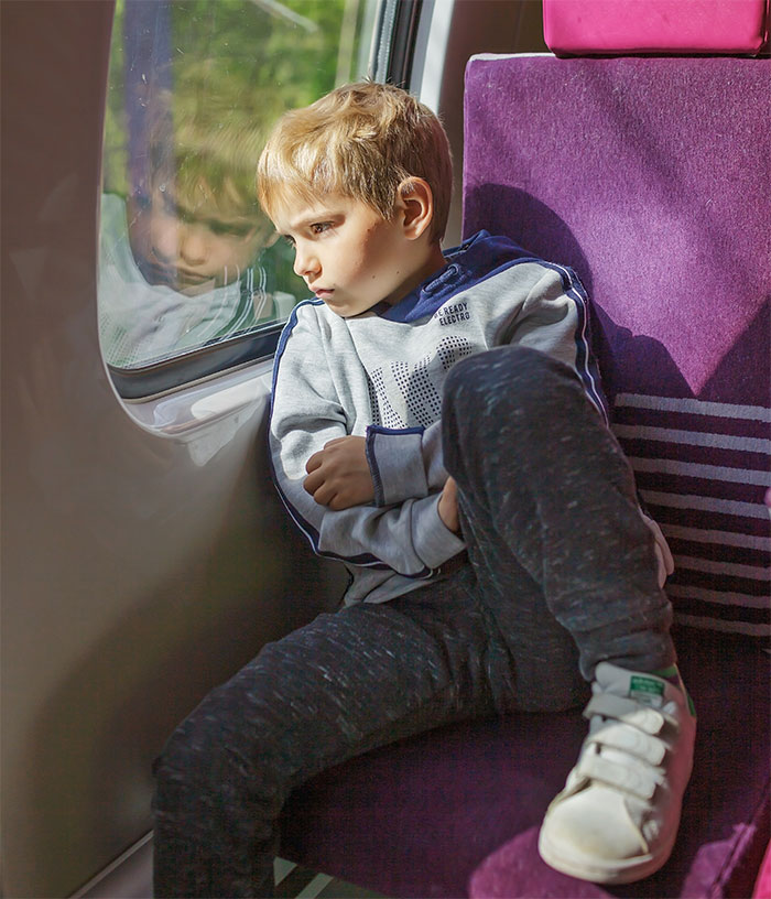 Child on a train looking out the window, reflecting on Santa Claus not being real.