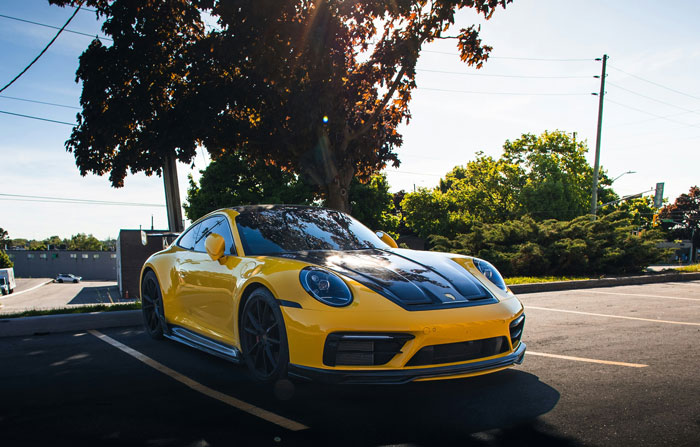 Yellow sports car parked in a lot, highlighting personal security measures for vehicles.