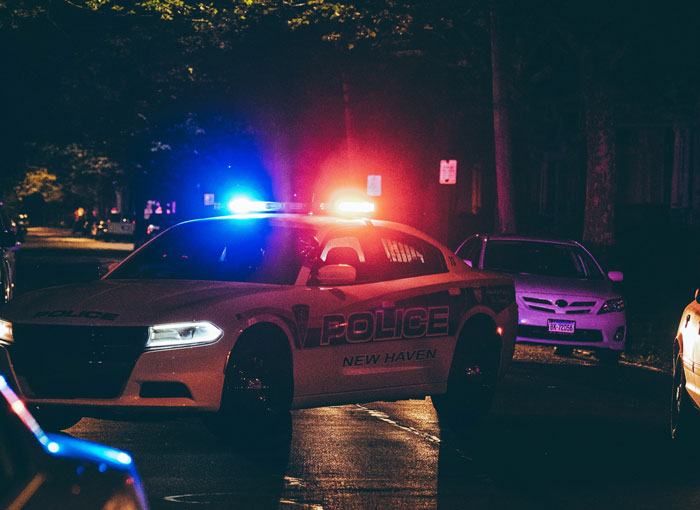 Police car with flashing lights at night, related to genuine speeding reasons shared with officers.